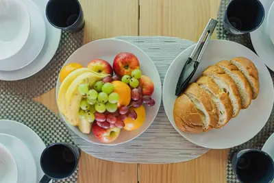 a table with two plates of fruit and a loaf of bread at AT Shinjuku in Tokyo