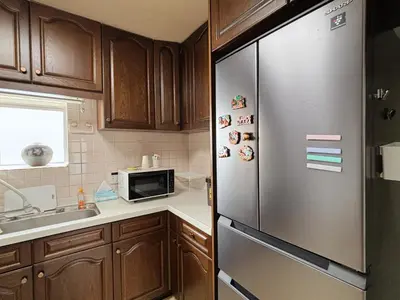 a kitchen with wooden cabinets and a stainless steel refrigerator at Direct to Shinjuku 15 mins 3rooms Up to 9 Guests in Tokyo