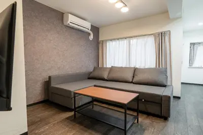 a living room with a couch and a table at Marble TOKYO Base Tabata 101 in Tokyo
