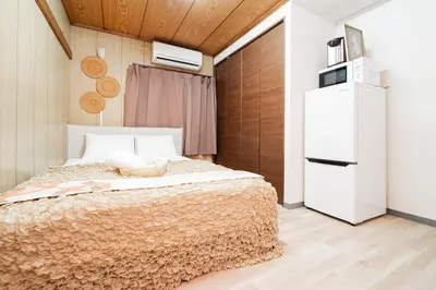 a bedroom with a bed and a refrigerator at Luna Nest Ikebukuro in Tokyo