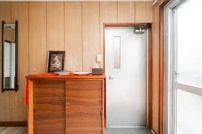 a room with a wooden cabinet and a door at Luna Nest Ikebukuro in Tokyo