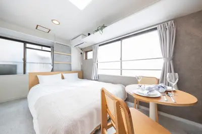 a bedroom with a large bed and a table with a tableasonable at 5 min to Shibuya, Easy Access to Hot Spots in Tokyo