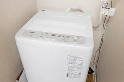 a white washing machine in a corner of a room at 5 min to Shibuya, Easy Access to Hot Spots in Tokyo