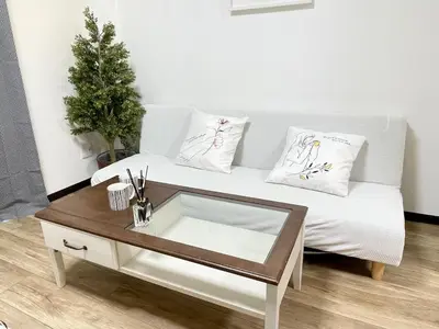 a white couch with pillows and a coffee table at M107 8mins from Ikebukuro sta 9min to Shinjuku byTrain in Tokyo