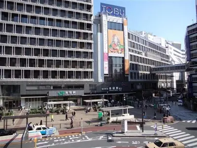a busy city street with a large building at M107 8mins from Ikebukuro sta 9min to Shinjuku byTrain in Tokyo