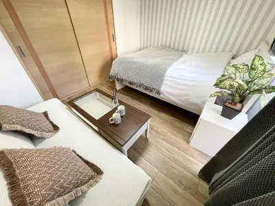 a small room with a bed and a table with a table at M107 8mins from Ikebukuro sta 9min to Shinjuku byTrain in Tokyo