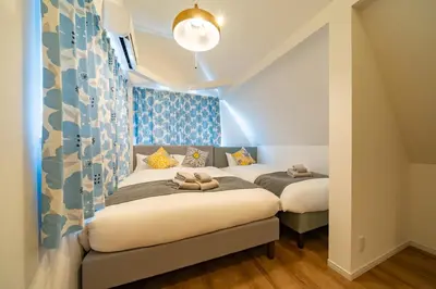 two beds in a small room with blue walls at \u845b\u98fe\u9ad8\u7802\u6238\u5efa in Tokyo