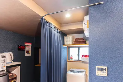 a bathroom with a blue shower curtain in a room at HOTEL Kita-Shinagawa in Tokyo