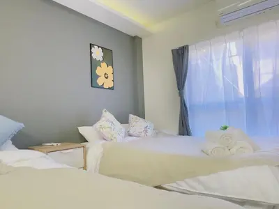 a bedroom with two beds and a window with towels at M103 8 mins to Ikebukuro sta in Tokyo