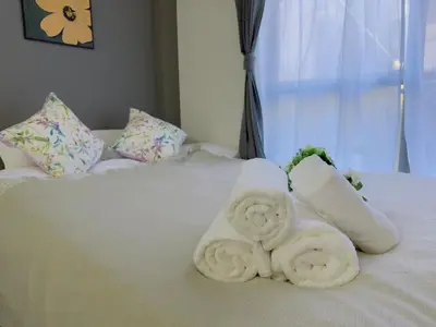 a white bed with towels on it with a window at M103 8 mins to Ikebukuro sta in Tokyo