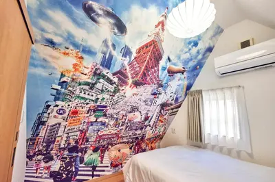 a bedroom with a mural of a city at \u3068\u307e\u308a\u30fc\u3068Stay \u7acb\u4f1a\u5ddd Tomareat Stay Tachiaigawa in Tokyo