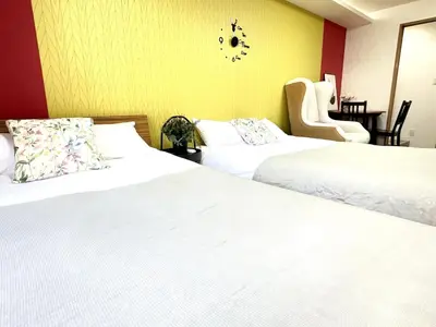 two beds in a hotel room with a chair at M108 8 mins to Ikebukuro sta in Tokyo