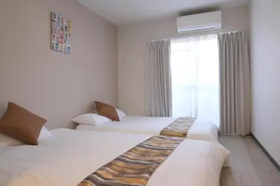 two beds in a hotel room with a window at Ikebukuro area 6mins from sta Max6 2 bedrooms N202 in Tokyo