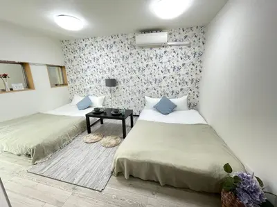 a room with two beds and a table in it at Ikebukuro area6mins from staMax4 2 double beds \u5357\u9577\u5d0e101 in Tokyo