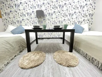 a living room with a table and two beds at Ikebukuro area6mins from staMax4 2 double beds \u5357\u9577\u5d0e101 in Tokyo