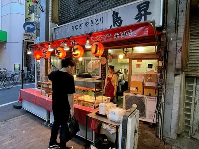 a man standing in front of a food stand at Ikebukuro area6mins from staMax4 2 double beds \u5357\u9577\u5d0e101 in Tokyo
