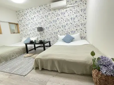 a bedroom with two beds and a wall with flowers at Ikebukuro area6mins from staMax4 2 double beds \u5357\u9577\u5d0e101 in Tokyo
