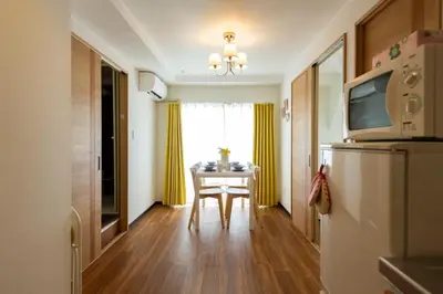 a kitchen with a table and a dining room with yellow curtains at Ikebukuro area6mins from staMax6 2 bedrooms\u5357\u9577\u5d0e401 in Tokyo