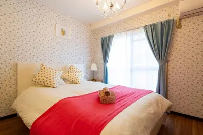 a bedroom with a large bed with a red blanket at Ikebukuro area6mins from staMax6 2 bedrooms\u5357\u9577\u5d0e401 in Tokyo