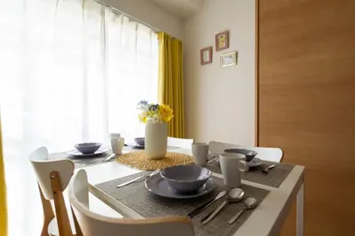 a dining room with a table with chairs and a vase of flowers at Ikebukuro area6mins from staMax6 2 bedrooms\u5357\u9577\u5d0e401 in Tokyo