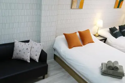 a bedroom with two beds and a couch at Easy access to Ikebukuro Red Leaves ,Golden GinkgoM303 in Tokyo