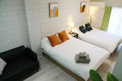 two beds in a small room with a chair at Easy access to Ikebukuro Red Leaves ,Golden GinkgoM303 in Tokyo