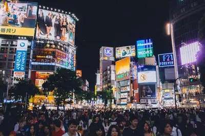 a crowd of people walking down a busy city street at night at Maple & Ginkgo ViewsAutumn Stay Near Ikebukuro N303 in Tokyo