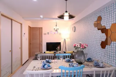 a dining room with a table with blue chairs at Maple & Ginkgo ViewAutumn Stay Near Ikebukuro N203 in Tokyo