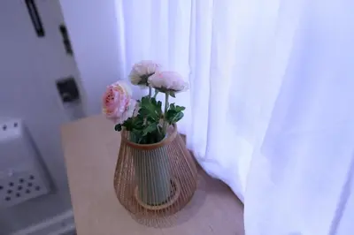 a vase with pink flowers sitting on a window sill at Maple & Ginkgo ViewAutumn Stay Near Ikebukuro N203 in Tokyo