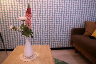 a white vase with flowers sitting on a table at Maple & Ginkgo ViewAutumn Stay Near Ikebukuro N203 in Tokyo
