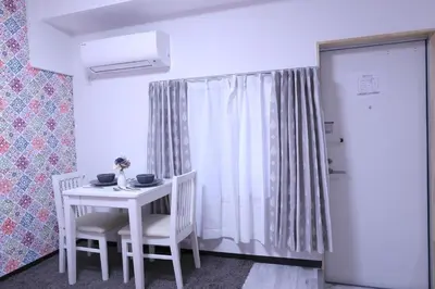a white table with two chairs and a white curtain at Maple & Ginkgo ViewsAutumn Stay Near Ikebukuro N105 in Tokyo