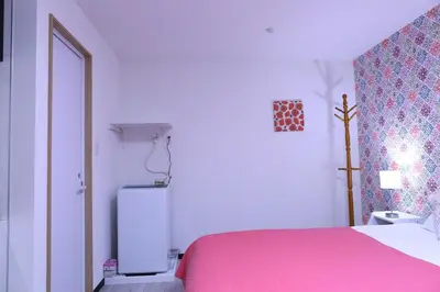 a bedroom with a pink bed and a small refrigerator at Maple & Ginkgo ViewsAutumn Stay Near Ikebukuro N105 in Tokyo
