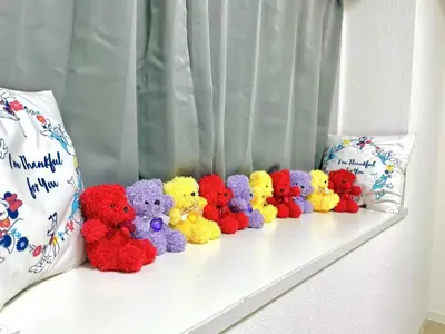 a row of stuffed teddy bears sitting on a window sill at \u6c60\u888b Bodo House 9 A5 in Tokyo