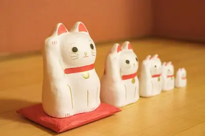 a group of white figurines of cats on a table at kt\u30d3\u30eb\u5343\u77f3 in Tokyo