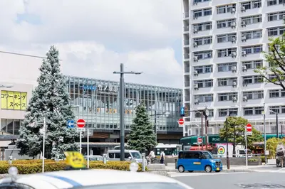 a parking lot with cars parked in front of a building at Cruise Inn Takenotsuka in Tokyo