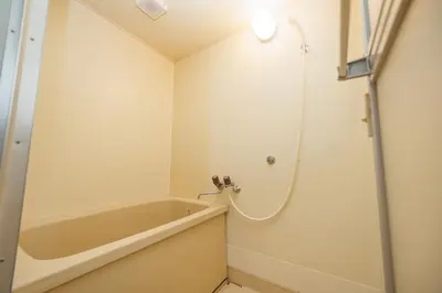 a small bathroom with a tub and a shower at Cruise Inn Takenotsuka in Tokyo