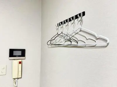 a metal hanger on a wall next to a phone at \u6c60\u888b IVY House B C 2 in Tokyo