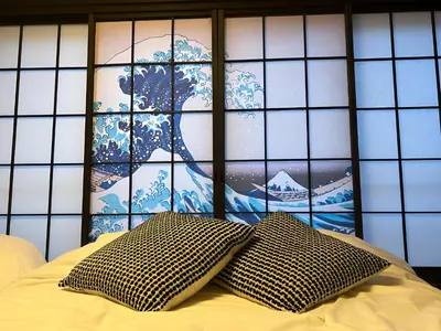 a pillow sitting on a bed in front of a window at Tiare Home MOTOHASUNUMA in Tokyo