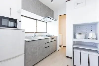 a kitchen with a sink and a microwave at Tiare Home MOTOHASUNUMA in Tokyo