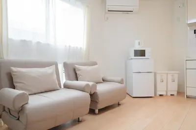 a living room with a couch and a chair at K06 Quiet 2LDK house on JR Yamanote Line Komagome Station in Tokyo