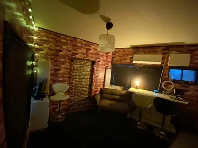 a living room with a brick wall with a desk and chairs at Popular Direct from the airport, perfect for getting anywhere in Tokyo, Skytree, Asakusa's best access private lodging Lcuky Smile in Tokyo