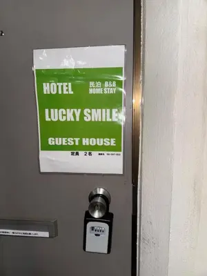 a sign on the door of a hotel lucky smile guest house at Popular Direct from the airport, perfect for getting anywhere in Tokyo, Skytree, Asakusa's best access private lodging Lcuky Smile in Tokyo