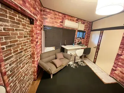 a room with a brick wall and a chair and a sink at Popular Direct from the airport, perfect for getting anywhere in Tokyo, Skytree, Asakusa's best access private lodging Lcuky Smile in Tokyo