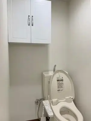a bathroom with a toilet with a white cabinet at Okubo, 20 seconds walk from JR Okubo Station in Tokyo