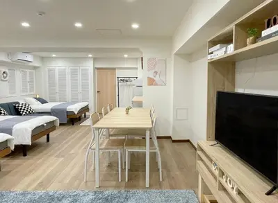 a living room with a dining table and a tv at Okubo, 20 seconds walk from JR Okubo Station in Tokyo