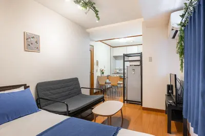 a room with a bed and a chair and a table at Cozy Apartment, 2min to Station , Direct to Skytree, Asakusa & Ueno & Narita ,駅2分,スカイツリー浅草上野成田空港直結,エレベーター,スーパー2分,コンビニ1分 in Tokyo