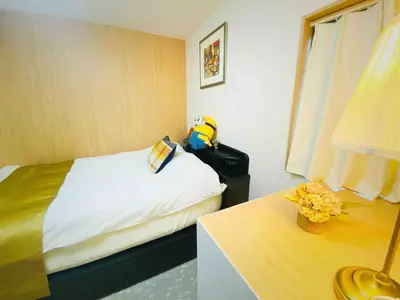 a bedroom with a bed and a table with a lamp at Pine House 6 minutes by train to Ikebukuro 11 minutes to Shinjuku Convenient access to Ueno by train in Tokyo