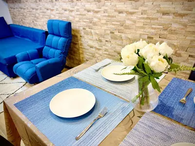 a table with white plates and a vase of flowers at Pine House 6 minutes by train to Ikebukuro 11 minutes to Shinjuku Convenient access to Ueno by train in Tokyo