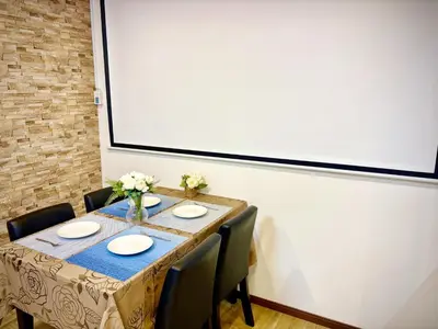 a table with chairs and a large projection screen at Pine House 6 minutes by train to Ikebukuro 11 minutes to Shinjuku Convenient access to Ueno by train in Tokyo