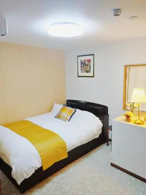 a bedroom with a bed with a yellow blanket at Pine House 6 minutes by train to Ikebukuro 11 minutes to Shinjuku Convenient access to Ueno by train in Tokyo